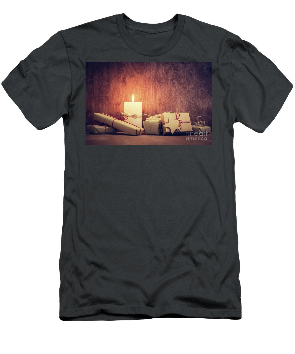 Chistmas Presents Gifts with a Candle Glowing on Wooden Wall Background Michal Bednarek T-Shirt