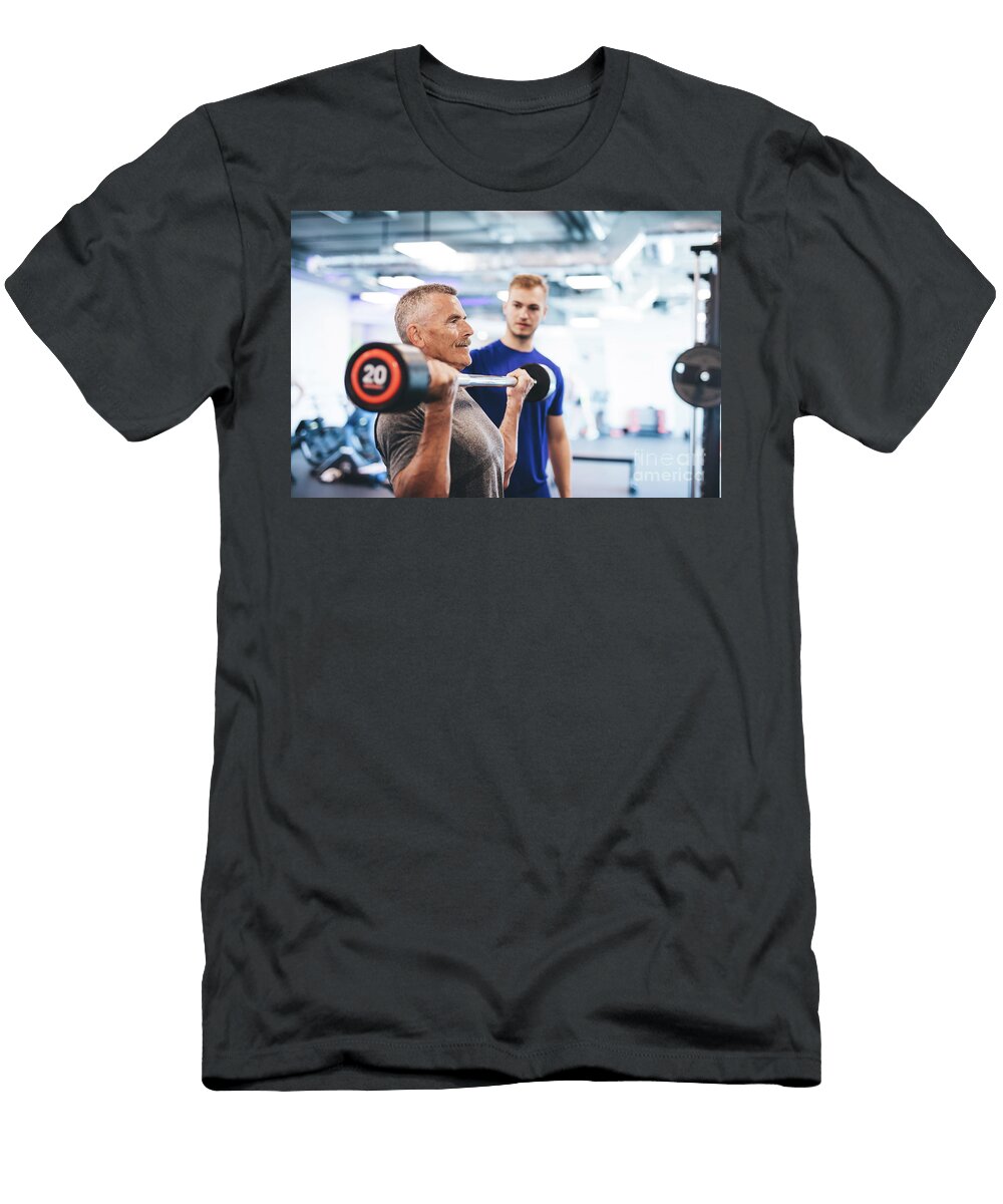 Older Man Lifting Weights Supervised By Gym Assistant Michal Bednarek T-Shirt