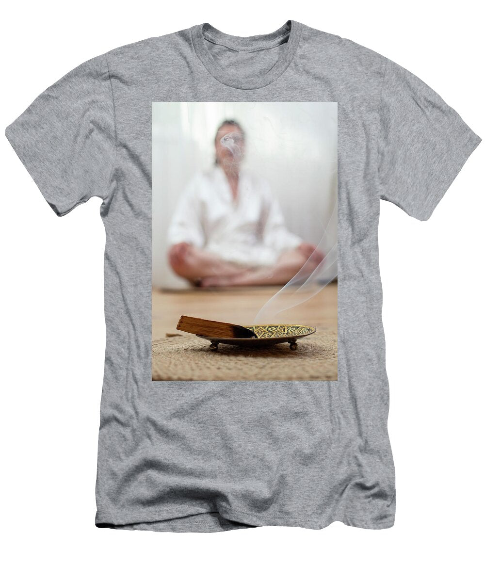 Smoking Palo Santo Incense Wood Burning in a Golden Tray with a Dorin Puha T-Shirt